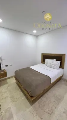 a bed in a room with a sign on the wall at Hotel Odonata Real in Cartagena de Indias