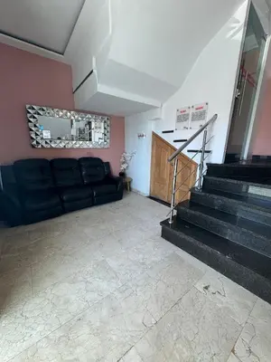 a living room with a black couch and stairs at Hotel Odonata Real in Cartagena de Indias