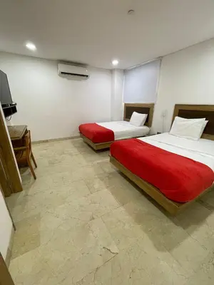 a bedroom with two beds and a television in it at Hotel Odonata Real in Cartagena de Indias