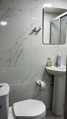 a white bathroom with a toilet and a sink at Acogedor y Moderno Apartamento en Barranquilla in Barranquilla
