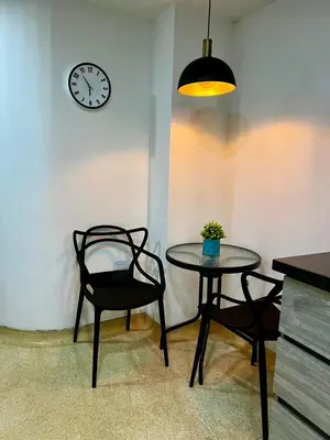a table and two chairs and a clock on a wall at Apartamento en Manga in Cartagena de Indias