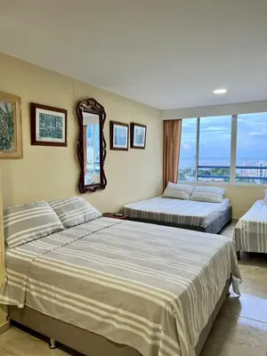 a bedroom with two beds and a mirror at Apartamentos Por dias Laguito Ctg in Cartagena de Indias