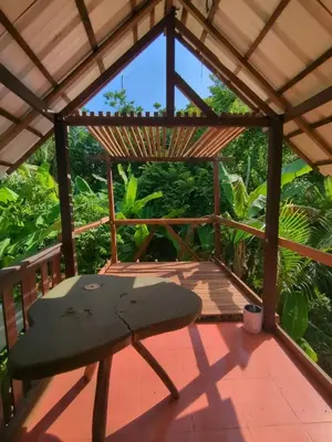 a wooden pergola with a surfboard on a deck at Lala's Place in Isla Fuerte
