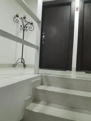 a staircase leading to a black door in a building at Habitacion en el Norte cerca al Malecón in Barranquilla