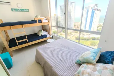 a bedroom with two bunk beds and a large window at Apartamento Oasis Cartagena in Cartagena de Indias