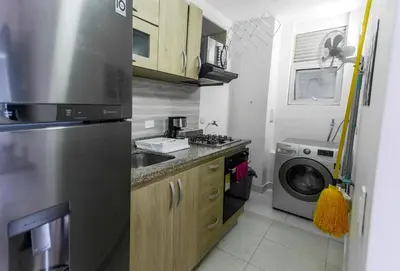 a kitchen with a stainless steel refrigerator and a washing machine at Apartamento Oasis Cartagena in Cartagena de Indias