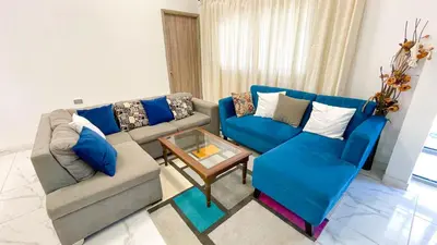 a living room with blue couches and a coffee table at Casa Elena in Tolú