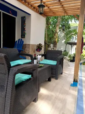 a patio with wicker chairs and tables on a deck at Cabaña Mary Mar en Isla in Cartagena in Isla de Tierra Bomba