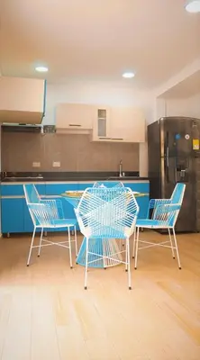 a kitchen with three chairs and a table and a refrigerator at Cabaña Mary Mar en Isla in Cartagena in Isla de Tierra Bomba