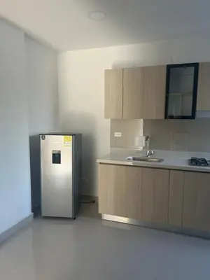 a kitchen with a stainless steel refrigerator and wooden cabinets at Aparta suite in Cartagena de Indias
