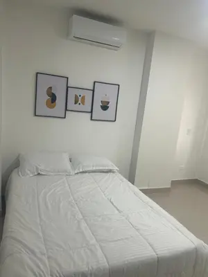 a bedroom with a white bed with pictures on the wall at Aparta suite in Cartagena de Indias