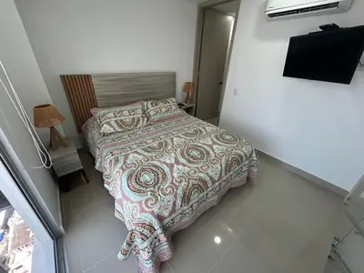 a small bedroom with a bed with a blanket at APARTAMENTO MAGNO LOFT Bocagrande in Cartagena de Indias