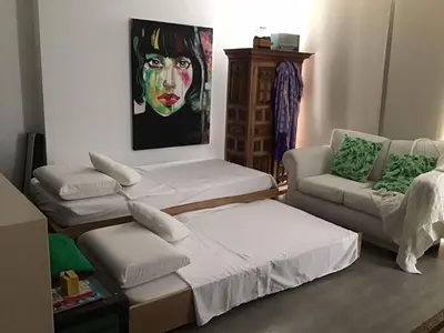 a room with three beds and a painting of a clown at Cartagena Colombia in Cartagena de Indias