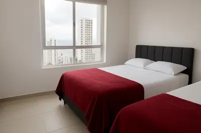 a bedroom with two beds and a window at Apartamento Cartagena exclusive in Cartagena de Indias