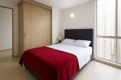 a bedroom with a large bed with a red blanket at Apartamento Cartagena exclusive in Cartagena de Indias