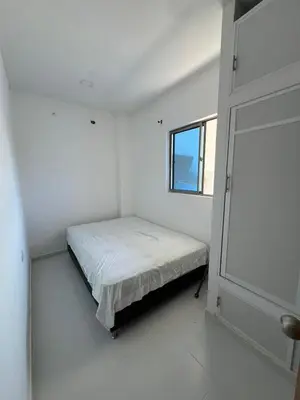 a small white bedroom with a bed and a window at Apartamentos Altos de Guayabal in El Triunfo