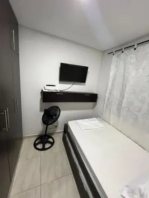 a bedroom with a bed and a desk and a television at ruiseñor 1 in Barranquilla