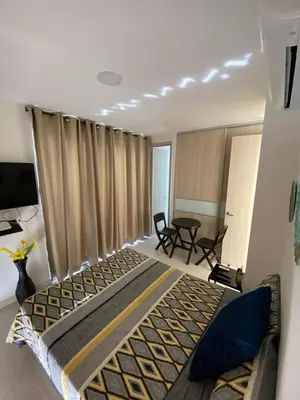 a bedroom with a large bed and a table at 1 bedroom apartment close to the beach in Cartagena de Indias