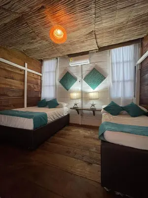 two beds in a room with two windows at Ikako beach club in Cartagena de Indias