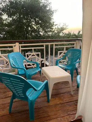 three blue chairs and a white table on a deck at Ikako beach club in Cartagena de Indias