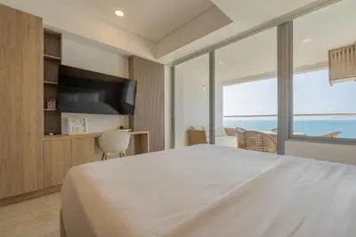 a bedroom with a large bed and a large window at Suite 15th floor con vista mar y piscina CB1511 in Cartagena de Indias