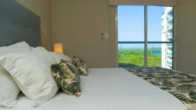 a bedroom with a bed with pillows and a window at New & Comfortable Apartment 2 BR In Cielo Mar in Cartagena de Indias