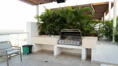 a barbecue grill sitting on a patio with plants at New & Comfortable Apartment 2 BR In Cielo Mar in Cartagena de Indias