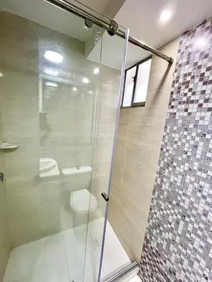 a bathroom with a glass shower with a toilet at Luxury loft with pool in Barranquilla