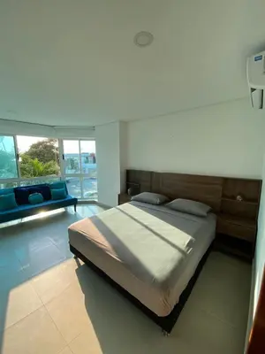 a bedroom with a large bed and a couch at Laguito Apartment in Cartagena de Indias