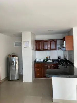 a kitchen with wooden cabinets and a stainless steel refrigerator at Laguito Apartment in Cartagena de Indias