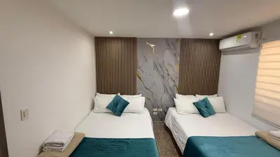 two beds in a small room withacers at Apartamentos Crespo 67 aeropuerto in Cartagena de Indias