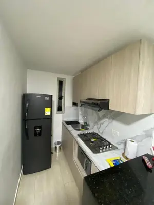 a small kitchen with a refrigerator and a stove at Apartamentos Crespo 67 aeropuerto in Cartagena de Indias