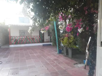 a courtyard with pink flowers and a fence at Cabaña Puerto Colombia CARNAVAL BARRANQUILLA 2025 in Puerto Colombia
