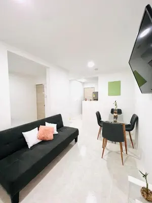 a living room with a black couch and a table at Cozy Beachside 3BR Apartment near the Walled City in Cartagena de Indias