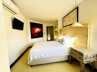 a bedroom with a white bed and a table at Auaecoco Hotel in Cartagena de Indias