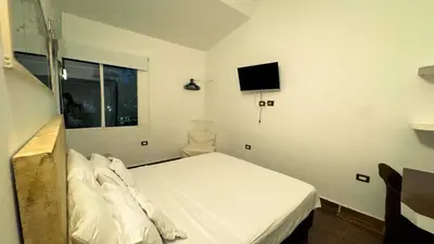 a bedroom with a bed and a tv on the wall at Auaecoco Hotel in Cartagena de Indias