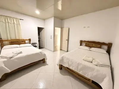 a bedroom with two beds and a hallway with a door at Apartments Tolú 3 habitaciones in Tolú