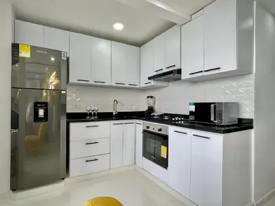 a kitchen with white cabinets and a stainless steel refrigerator at Apartamento con vista única cerca de la Uninorte in Puerto Colombia