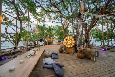 a table with pillows on a wooden floor with trees at Isla Corona in Baru