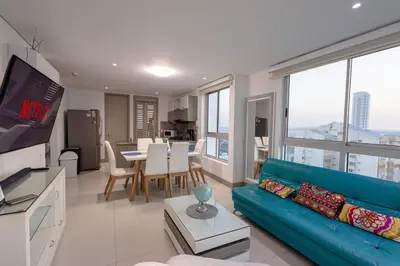 a living room with a blue couch and a table at Majestic apt with an ocean view Palmetto Beach in Cartagena de Indias