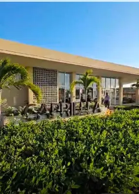 a building with palm trees in front of it at Tu refugio perfecto in Manzanillo del Mar