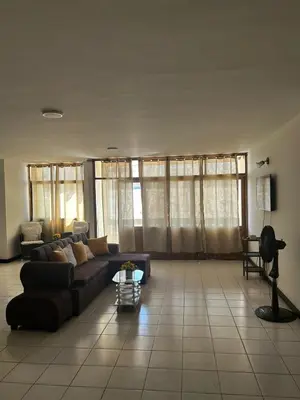 a living room with a couch and some windows at Hostal Tayrona in Santa Marta