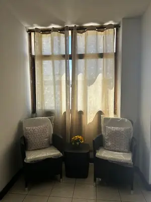 two chairs and a table in front of a window at Hostal Tayrona in Santa Marta