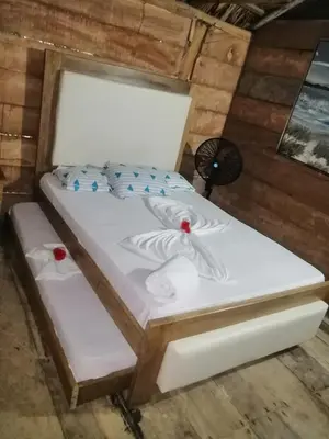 a white bed in a room with a fan at Tropical Beach in Playa Blanca