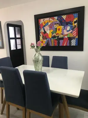 a white table with chairs and a vase with flowers on it at Apartamento Carnavalero calle 72, ubicación privilegiada eventos de carnaval zona norte in Barranquilla