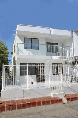 a white house with a fence in front of it at La Armonia in Cartagena de Indias