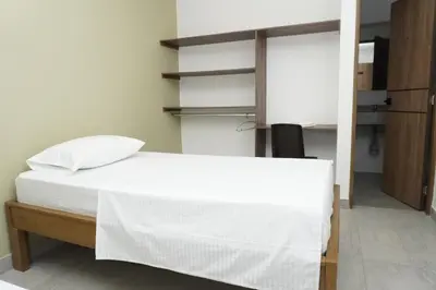 a bedroom with a white bed and a closet at Hotel INdustrial in Sincelejo
