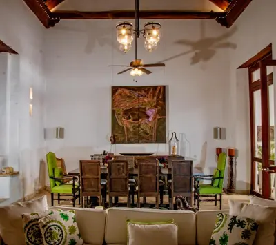 a dining room with a table and green chairs at 5 BR Villa inside of the walled city in Cartagena de Indias