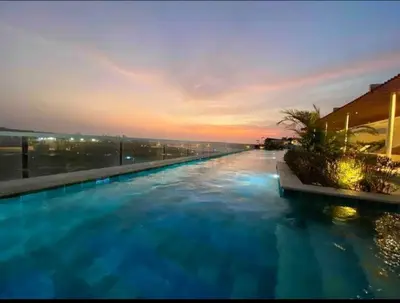 a large swimming pool with a sunset in the background at Como estar en casa! in Cartagena de Indias