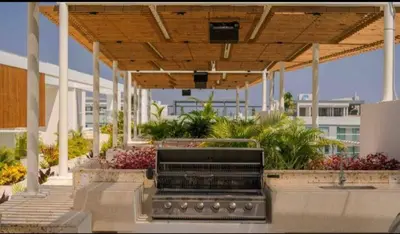 a patio with a wooden roof and flowers and plants at Como estar en casa! in Cartagena de Indias